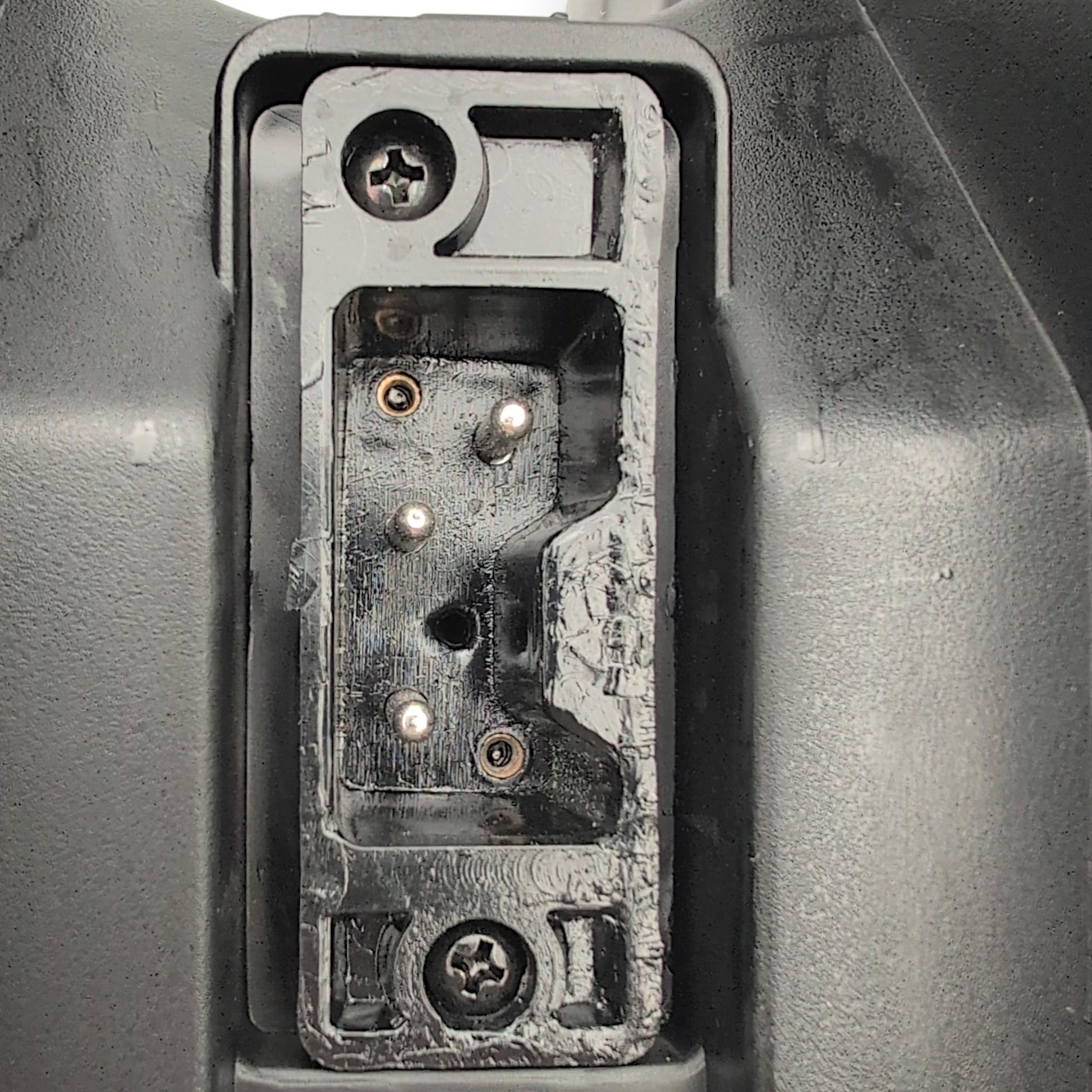 Closeup o the 3-pin port on the bottom of the battery box. used to connect the battery box to the scooter