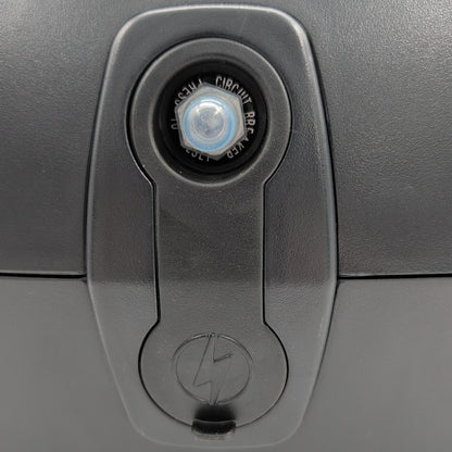 close up of charger port with cover on. Showing: 20 amp circuit breaker reset button